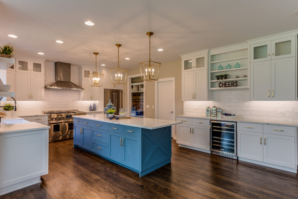Calabasas Kitchen Remodel Farmhouse kitchen with blue shaker island, white subway tile backsplash, and brass pendant lights in Calabasas by RnD Builders Inc