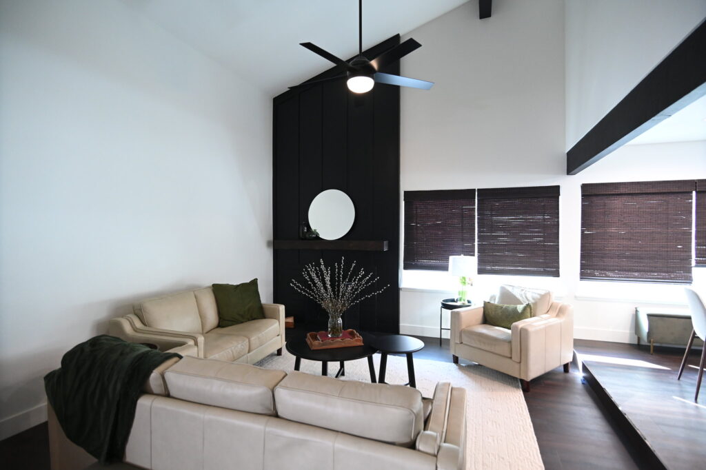 Vaulted Living Room with Black Shiplap Accent Wall in Simi Valley Vaulted living room with black shiplap accent wall, cream leather seating, and dark hardwood floors in Simi Valley by RnD Builders Inc