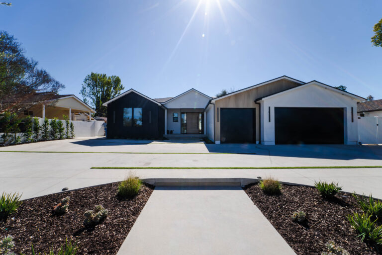 Modern Farmhouse Exterior with Black Board-and-batten Siding in Woodland Hills Modern farmhouse exterior with black board-and-batten siding, white stucco, and three-car garage in Woodland Hills by RnD Builders Inc