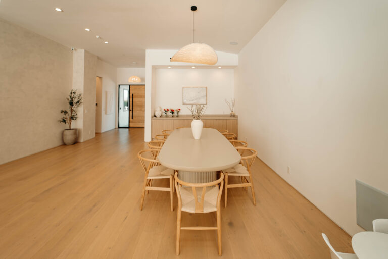 Open-concept Dining Room with Oval Table in Woodland Hills Open-concept dining room with oval table, wishbone chairs, and woven pendant light in Woodland Hills by RnD Builders Inc