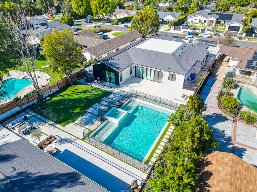 Aerial View of Modern White Stucco Home in Woodland Hills Aerial view of modern white stucco home with rectangular pool, spa, and artificial turf backyard in Woodland Hills by RnD Builders Inc
