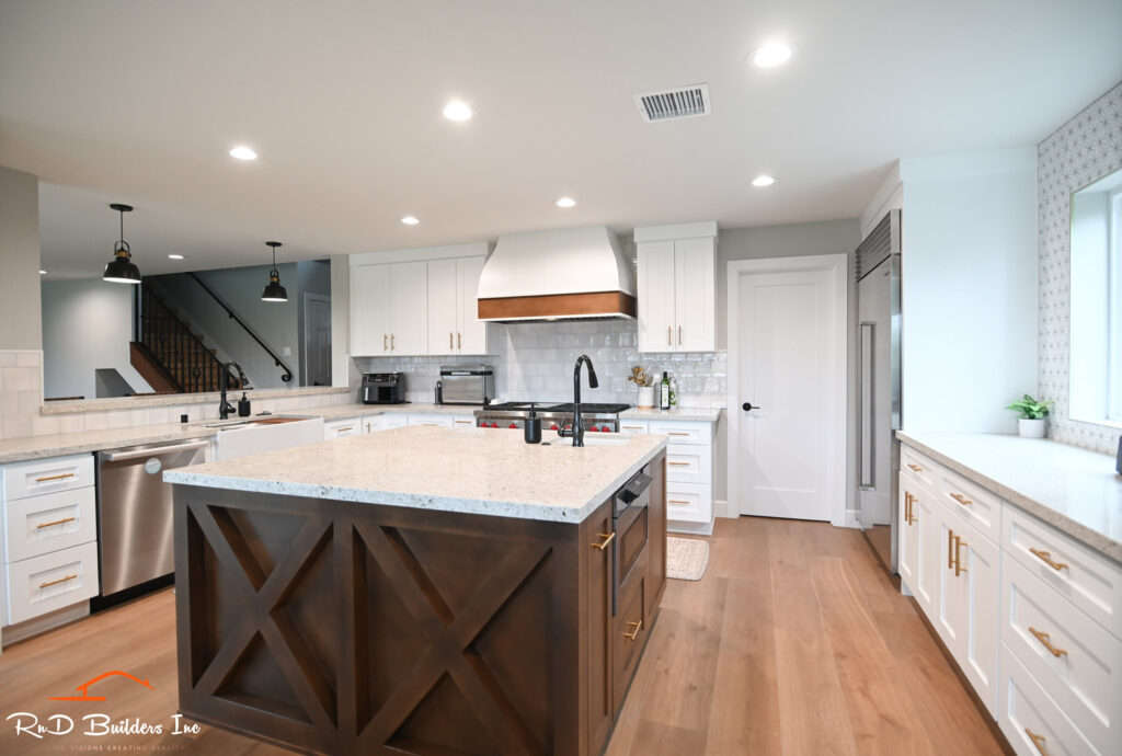 Open-concept Kitchen Remodel Remodeling in Newbury Park: Open-concept kitchen remodel with dark walnut X-detail island, white shaker cabinets, and granite countertops by RnD Builders Inc