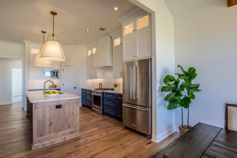 Transitional kitchen with navy lower cabinets, white uppers, knotty alder island, and stainless steel appliances in Westlake Village by RnD Builders Inc