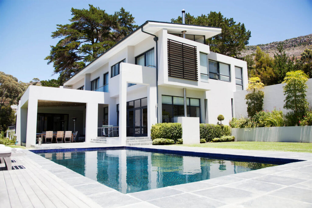 Two-story Modern White Stucco Home Two-story modern white stucco home with rectangular pool and outdoor dining patio by RnD Builders Inc