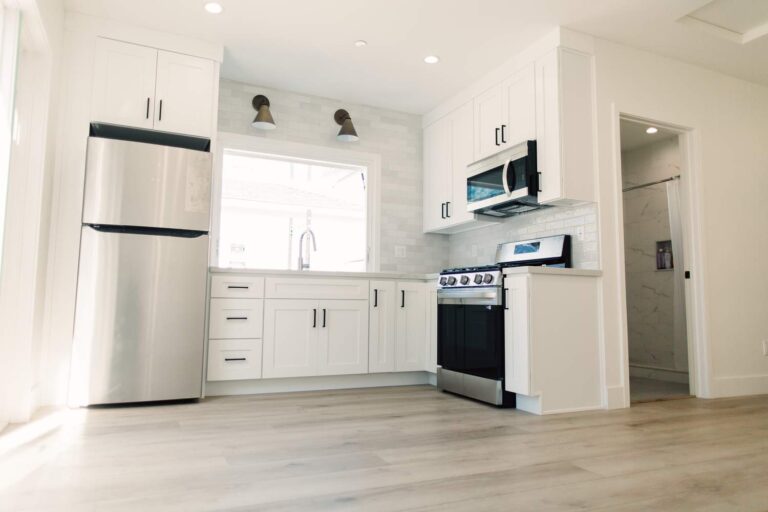 Bright White Shaker Cabinet Kitchen in Hawthorne Bright white shaker cabinet kitchen with stainless steel appliances and light wood-look flooring in Hawthorne by RnD Builders Inc