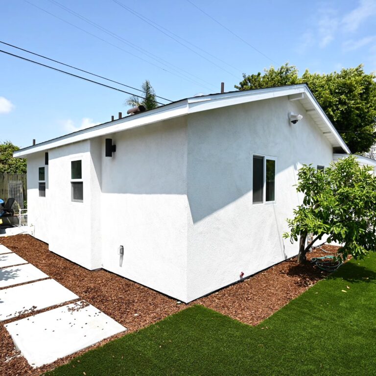 White Stucco ADU Exterior with Gable Roof White stucco ADU exterior with gable roof, concrete pavers, and artificial turf landscaping by RnD Builders Inc