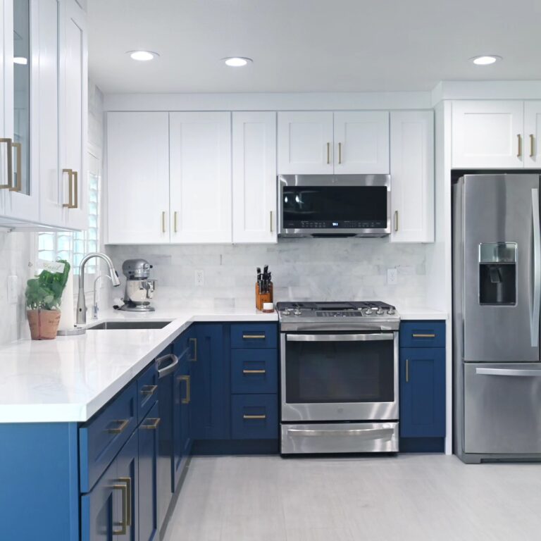 Two-tone Kitchen with Navy Blue Lower Cabinets Two-tone kitchen with navy blue lower cabinets, white upper shaker cabinets, and stainless steel appliances by RnD Builders Inc