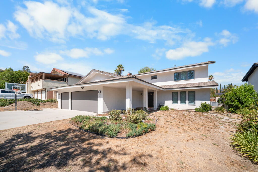 Two-story stucco home with three-car garage, tile roof, and drought-tolerant landscaping by RnD Builders Inc