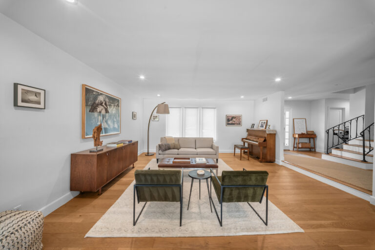 Open-concept Living Room with Hardwood Floors in Calabasas Open-concept living room with hardwood floors, mid-century furniture, and staircase in Calabasas by RnD Builders Inc