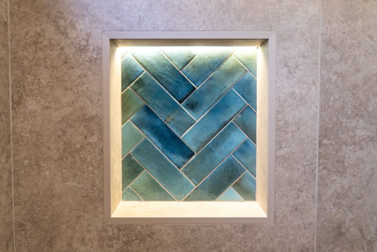 Agoura Hills bathroom remodel: Recessed shower niche with blue-green herringbone tile and LED strip lighting in Agoura Hills by RnD Builders Inc
