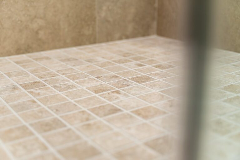 Agoura Hills bathroom remodel: Close-up of beige travertine mosaic tile shower floor with white grout lines in Agoura Hills by RnD Builders Inc