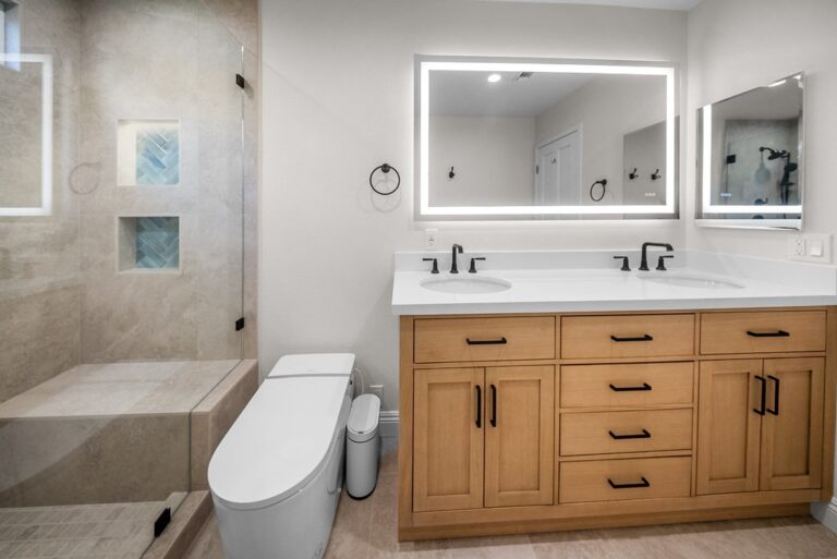 Agoura Hills bathroom remodel: Modern bathroom remodel with oak vanity, dual sinks, LED mirror, and tiled walk-in shower in Agoura Hills by RnD Builders Inc