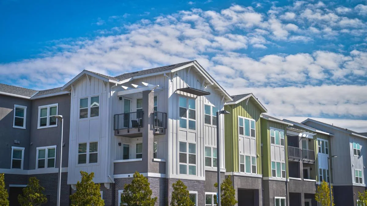 Multi-story residential building with board-and-batten siding, balconies, and mixed exterior finishes by RnD Builders Inc