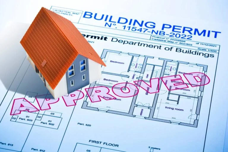 Approved building permit document with residential floor plan blueprints and miniature house model by RnD Builders Inc