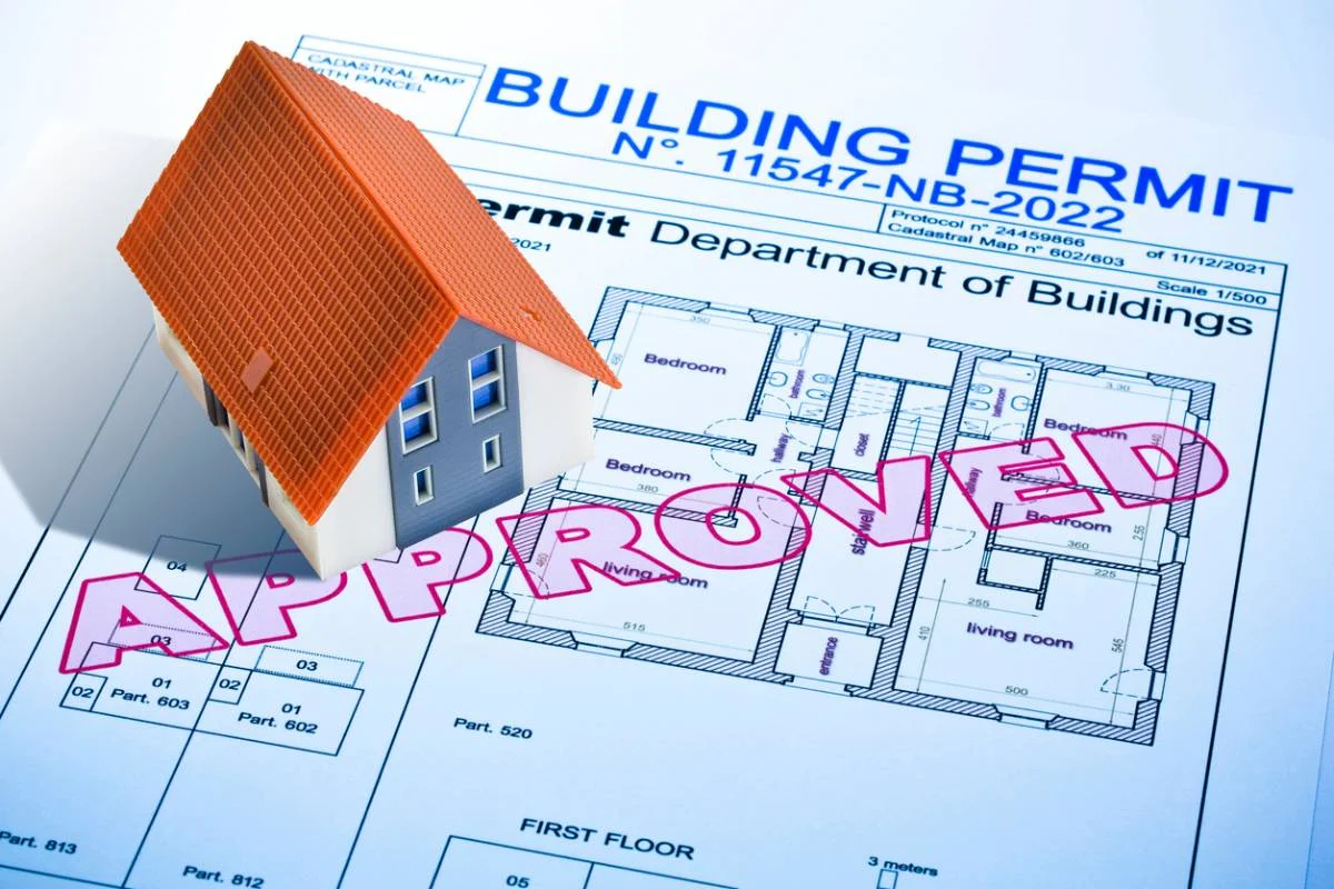 Approved building permit document with residential floor plan blueprints and miniature house model by RnD Builders Inc