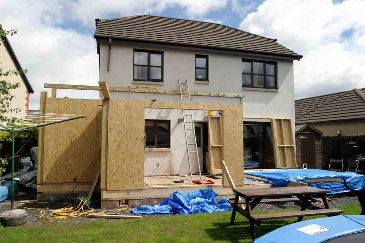 Rear home addition under construction with OSB sheathing and timber framing by RnD Builders Inc