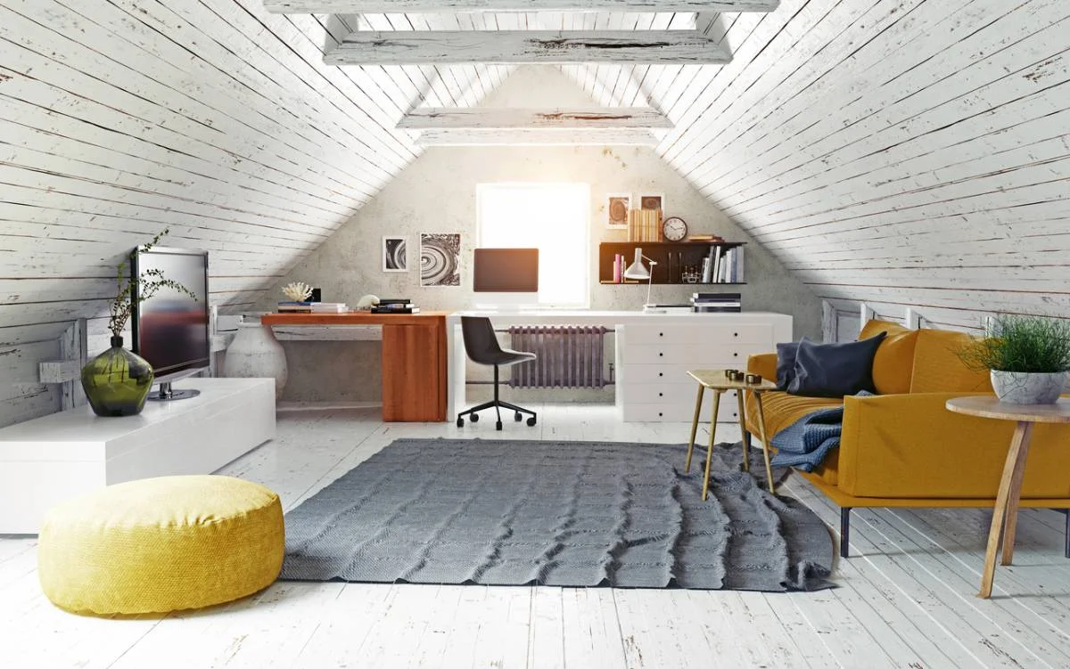Attic conversion home office with vaulted whitewashed wood ceiling, walnut desk, and mustard sofa by RnD Builders Inc