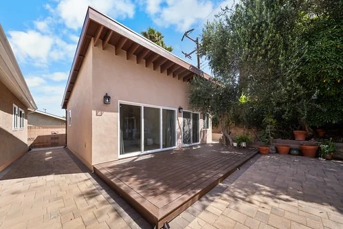 Stucco ADU exterior with wood deck and sliding glass door by RnD Builders Inc