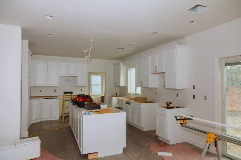 Kitchen remodel in progress with white raised-panel cabinets and center island by RnD Builders Inc