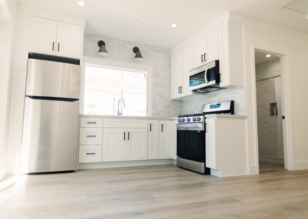 Bright White Shaker Cabinet Kitchen Garage conversion kitchen with white shaker cabinets and stainless appliances in a converted garage ADU by RnD Builders