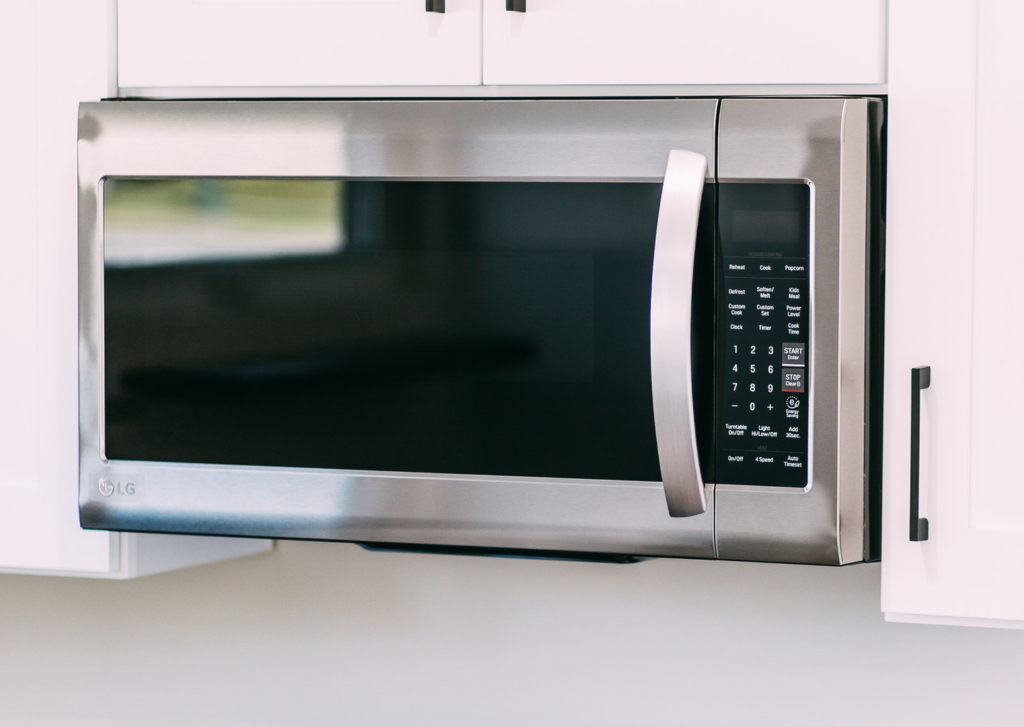 Stainless Steel LG Over-the-range Microwave Installed Stainless steel LG over-the-range microwave installed beneath white shaker cabinets by RnD Builders Inc