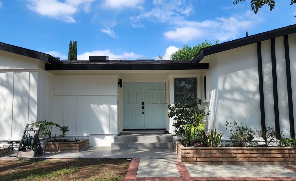 Single-story home exterior with mint green double entry door and black trim accents by RnD Builders Inc