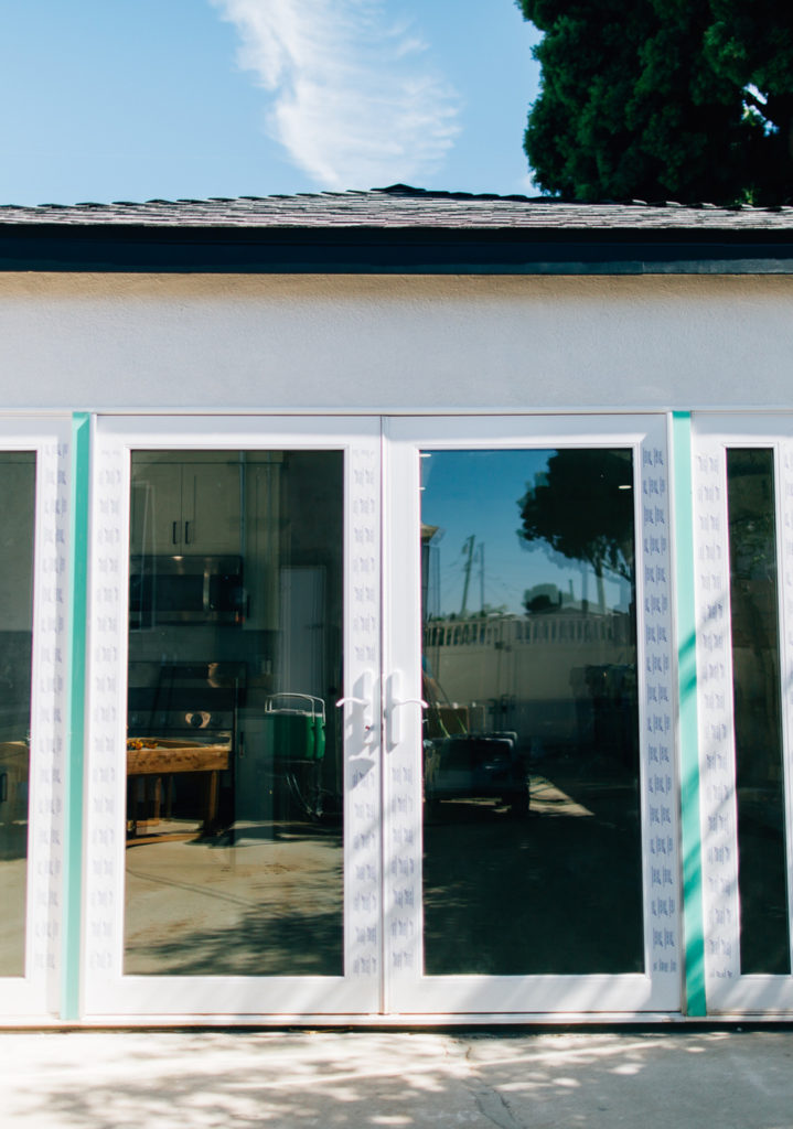 Newly Installed White-framed French Doors Newly installed white-framed French doors with protective film on stucco exterior under asphalt shingle roof by RnD Builders Inc