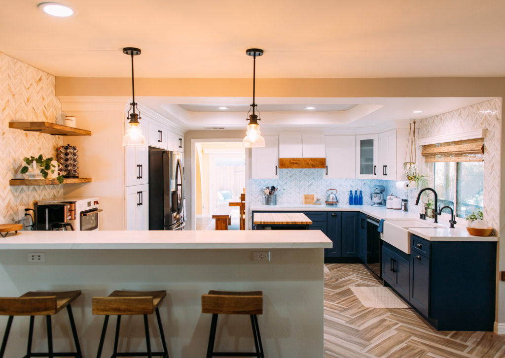 Thousand Oaks farmhouse kitchen: Two-tone kitchen with navy lower cabinets, white uppers, herringbone backsplash, and farmhouse sink in Thousand Oaks by RnD Builders Inc