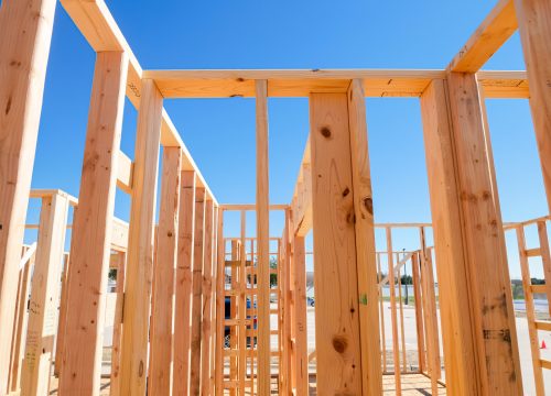 Close-up wooden framing, joints, post, beam connection of medium size single family residential home, Dallas, Texas, interior view traditional timber house new build construction, clear blue sky. USA