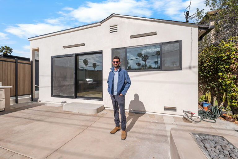 Rear of Home with Sliding Door and Horizontal Window with a black-framed sliding door, a wide window and smooth white stucco in Manhattan Beach by RnD Builders Inc