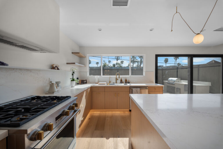 Kitchen Range with Open Shelving with a gas range, a range hood, open shelves and a quartz island in Manhattan Beach by RnD Builders Inc