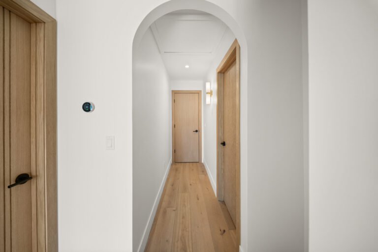 Arched Hallway with Wood Interior Doors with an arched opening, wide-plank flooring and light wood doors in Manhattan Beach by RnD Builders Inc