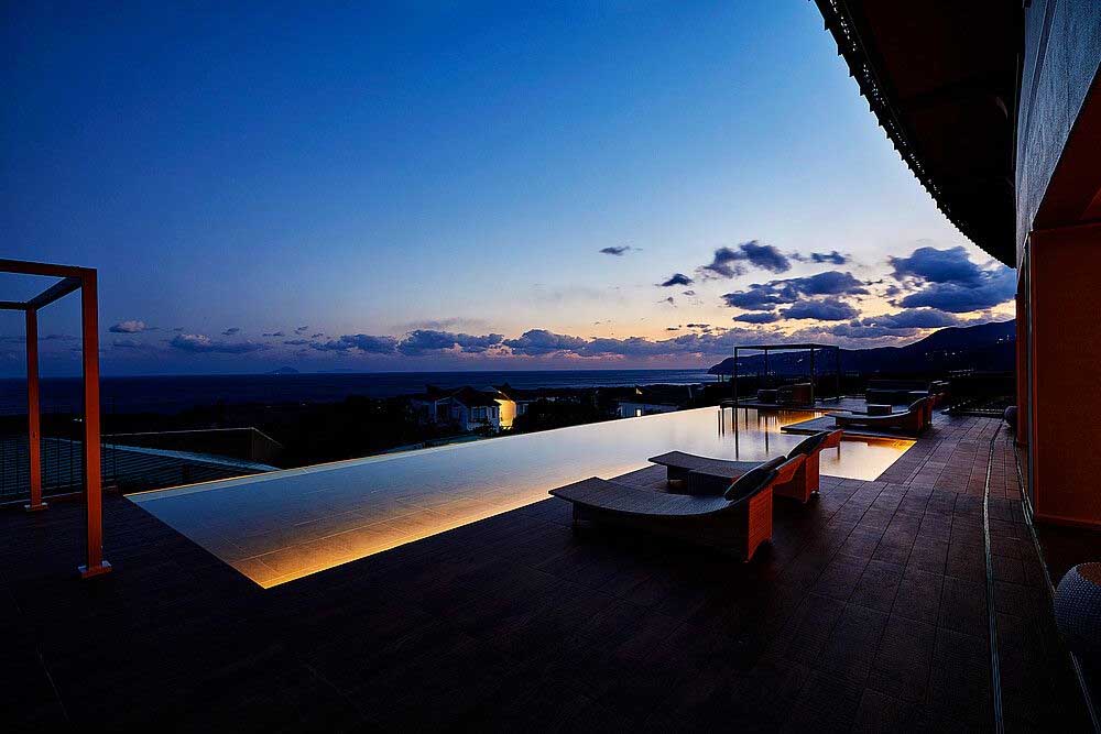 backyard swimming pool with ambient outdoor lighting at night