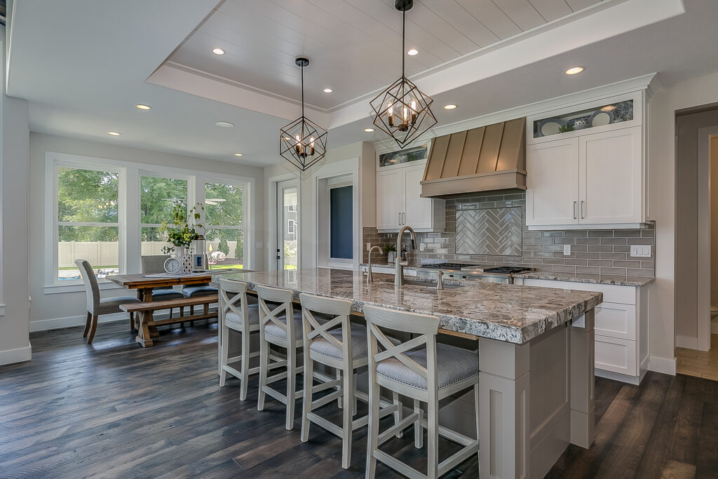 Camarillo kitchen remodel: Open-concept kitchen with granite island, white shaker cabinets, and gray subway tile backsplash in Camarillo by RnD Builders Inc