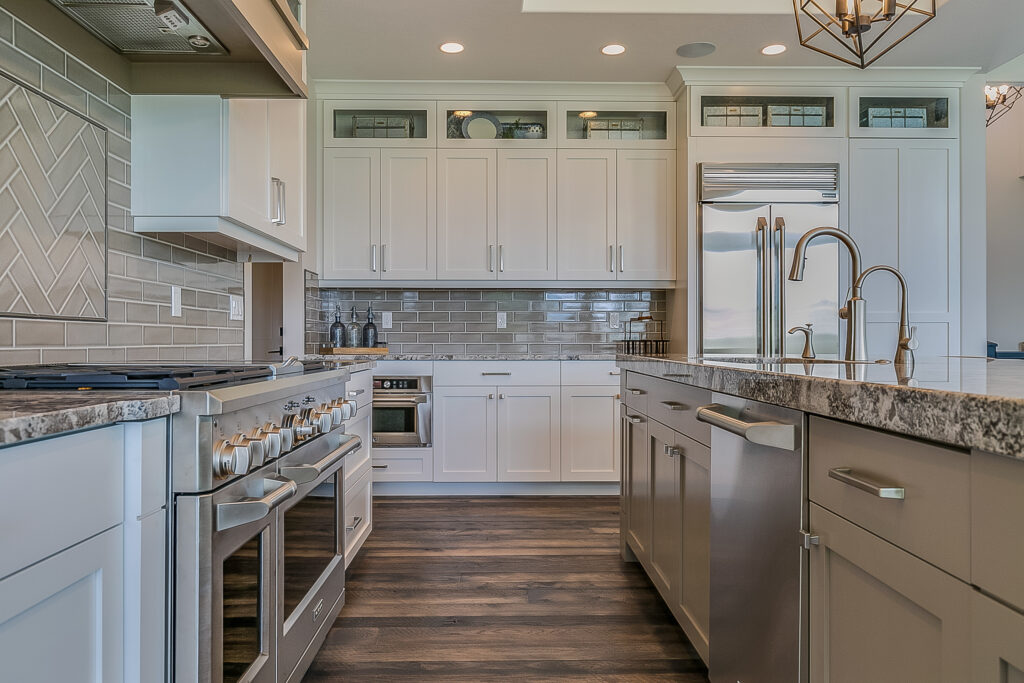 Camarillo kitchen remodel: Transitional white shaker kitchen with stainless steel appliances, gray subway tile backsplash, and dark hardwood floors in Camarillo by RnD Builders Inc