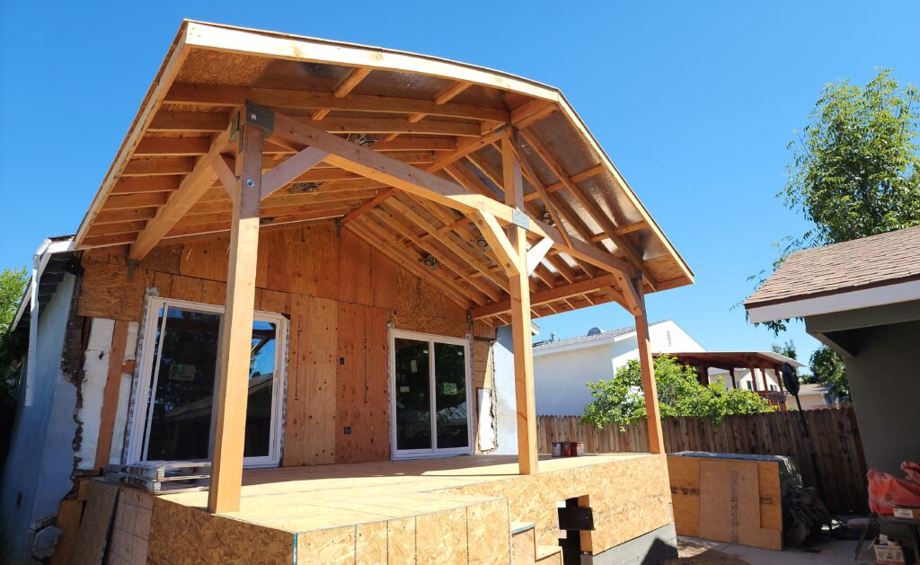 Thousand Oaks patio cover: Residential room addition under construction with timber-framed gable patio cover and OSB sheathing in Thousand Oaks by RnD Builders Inc