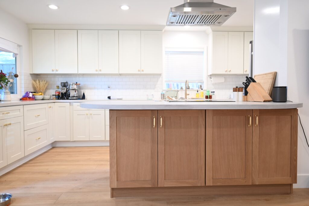 Two-tone kitchen with white shaker cabinets, natural oak island, and white quartz countertops by RnD Builders Inc