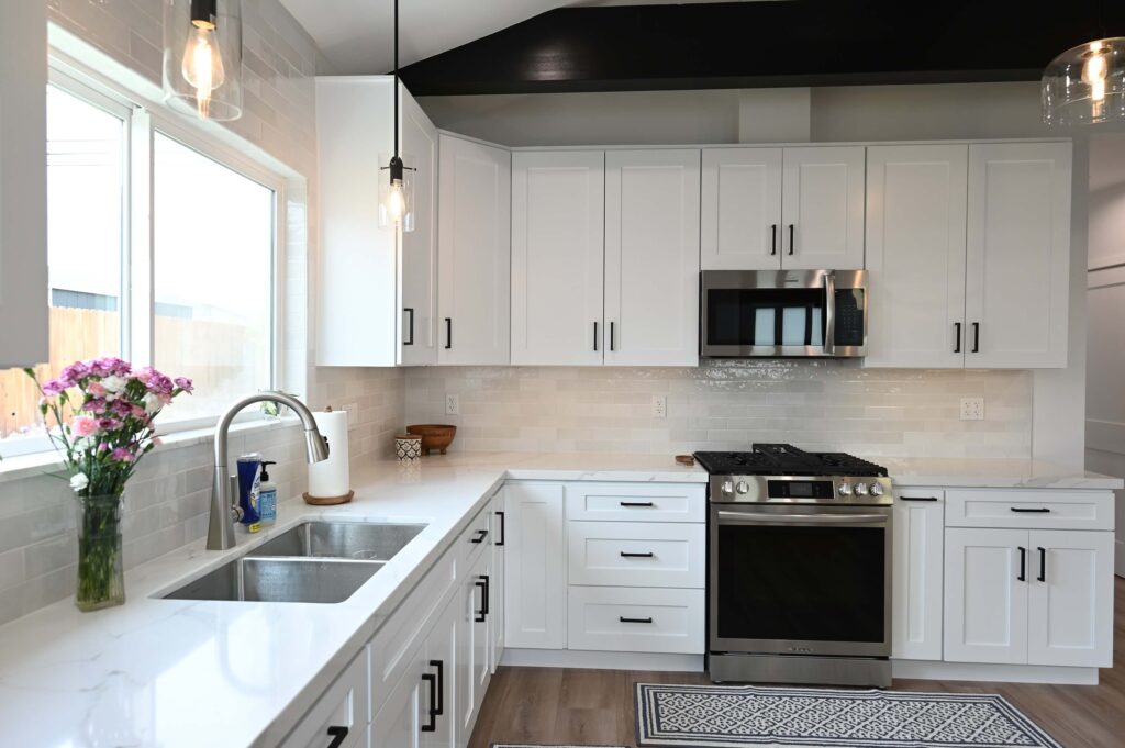 White Shaker Cabinet Kitchen with Quartz Countertops Hawthorne 750 sqft ADU: Hawthorne 750 sqft ADU: White shaker cabinet kitchen with quartz countertops, subway tile backsplash, and stainless steel appliances in Hawthorne by RnD Builders Inc