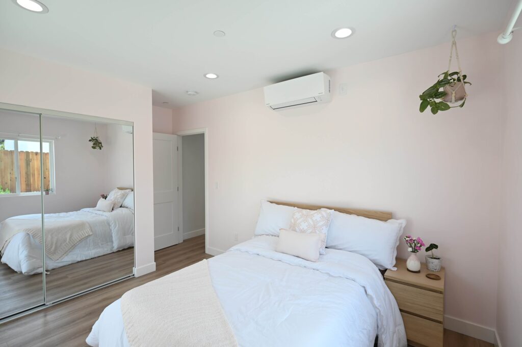Bright Bedroom with Blush Walls Home remodeling contractor in Hawthorne: new 750 sq ft ADU interior with shaker cabinets and quartz counters by RnD Builders
