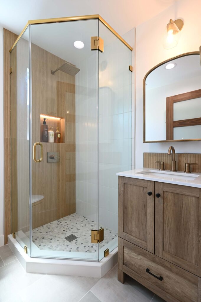 Transitional Bathroom with Neo-angle Glass Shower Transitional bathroom with neo-angle glass shower, wood-look tile, and rustic wood vanity by RnD Builders Inc