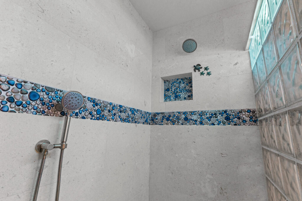 Thousand Oaks walnut bathroom: Walk-in shower with blue pebble mosaic tile border, rain head, and glass block window in Thousand Oaks by RnD Builders Inc
