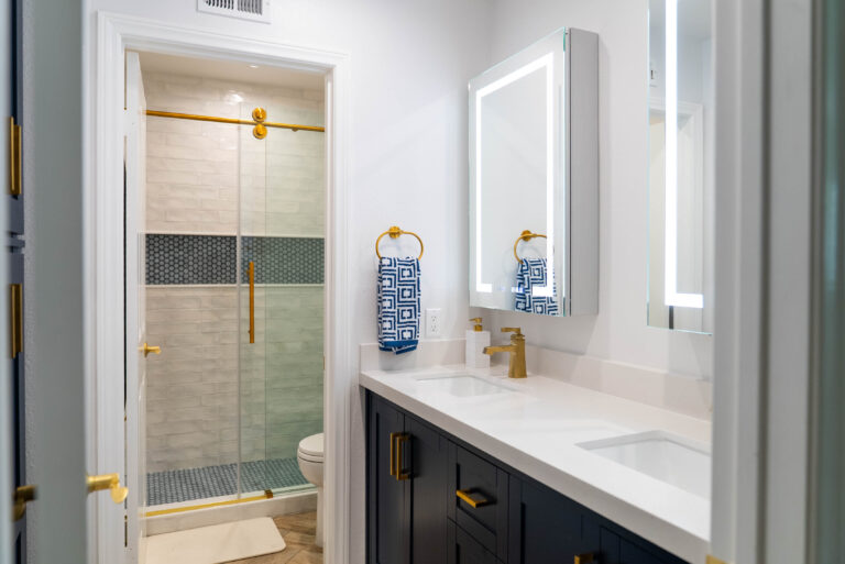 A bathroom interior with a white sink and a gold sink, emphasizing a chic and sophisticated look.