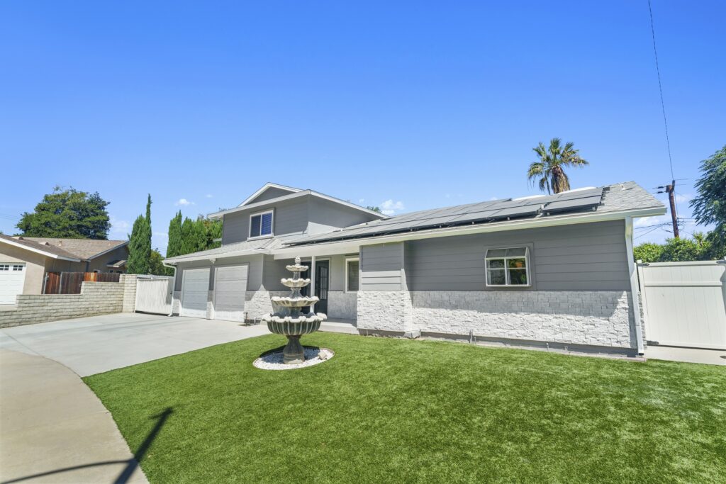 Two-story Gray Home with Stone Veneer Base in Simi Valley Two-story gray home with stone veneer base, solar panels, three-car garage, and decorative fountain in Simi Valley by RnD Builders Inc