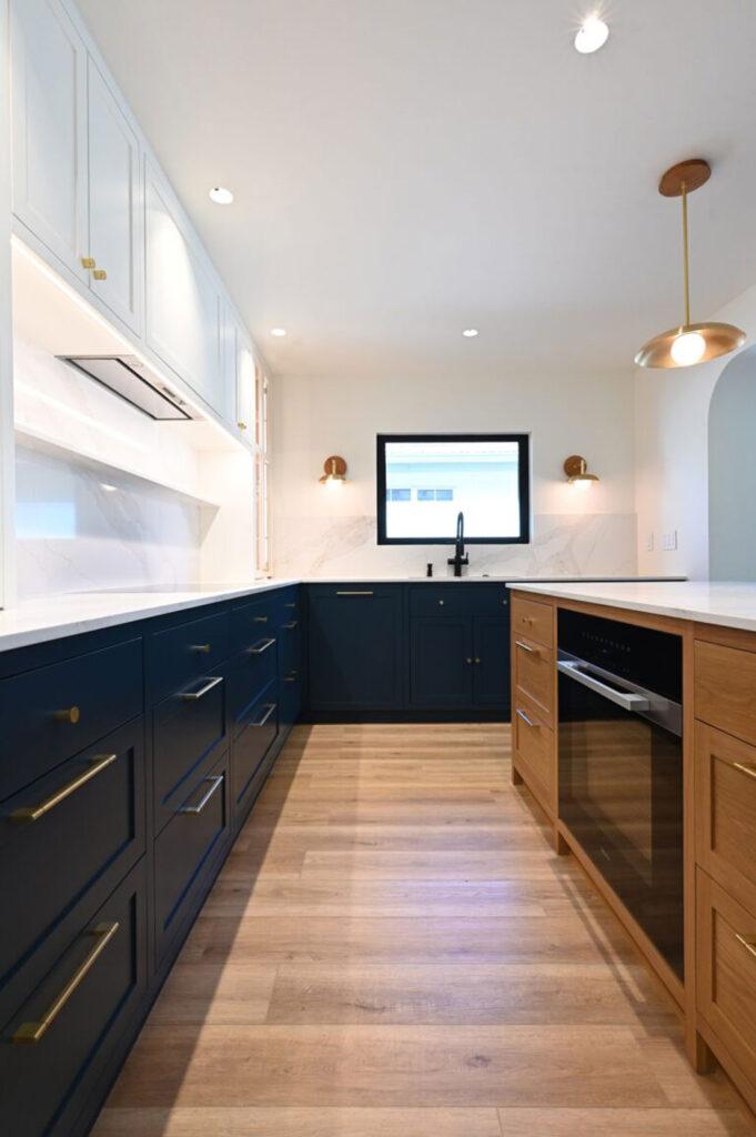 U-shaped Kitchen with Navy Shaker Cabinets U-shaped kitchen with navy shaker cabinets, white upper cabinets, and warm wood island by RnD Builders Inc