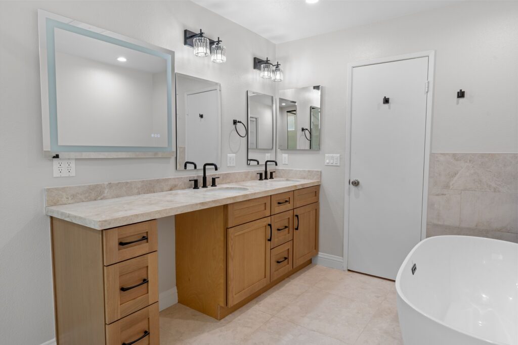 Thousand Oaks full remodel: Master bathroom with double vanity, light wood shaker cabinets, stone countertop, and freestanding soaking tub in Thousand Oaks by RnD Builders Inc