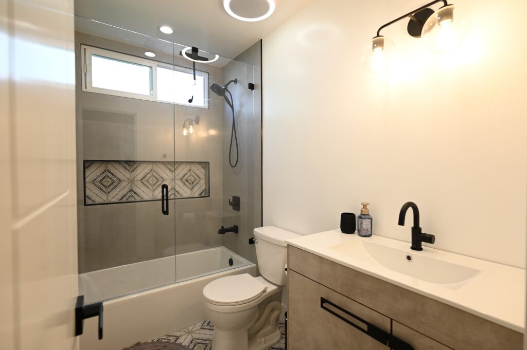 Modern Bathroom Remodel with Glass Shower Enclosure West Hills full remodel: Modern bathroom remodel with glass shower enclosure, patterned tile niche, and floating vanity in West Hills by RnD Builders Inc