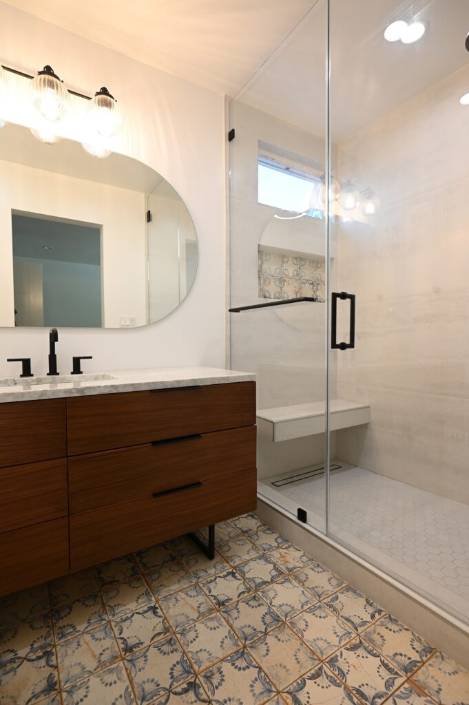 West Hills full remodel: Mid-century modern bathroom with walnut floating vanity, encaustic floor tile, and frameless glass shower in West Hills by RnD Builders Inc