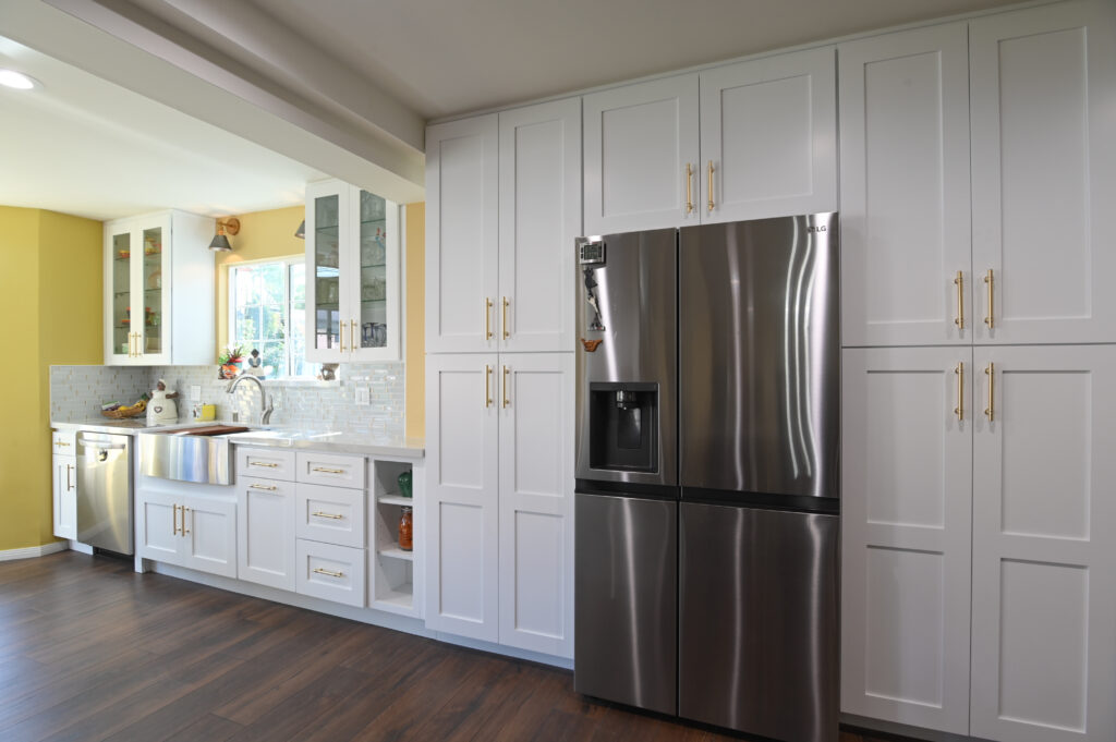 White shaker cabinet kitchen remodel with stainless LG refrigerator and gold hardware by RnD Builders Inc