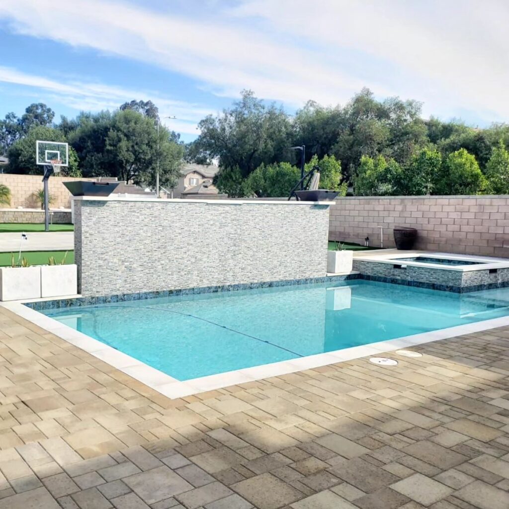 Modern Rectangular Pool with Stacked Stone Water Wall in Los Angeles Modern rectangular pool with stacked stone water wall, spa, and paver deck in Los Angeles by RnD Builders Inc