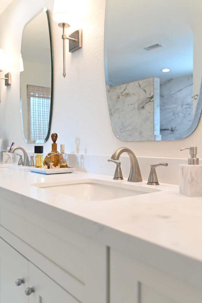 Moorpark bathroom remodel: Double sink bathroom vanity with white quartz countertop, brushed nickel faucets, and arched mirrors in Moorpark by RnD Builders Inc